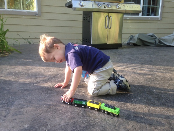 Cody playing with toy train outside